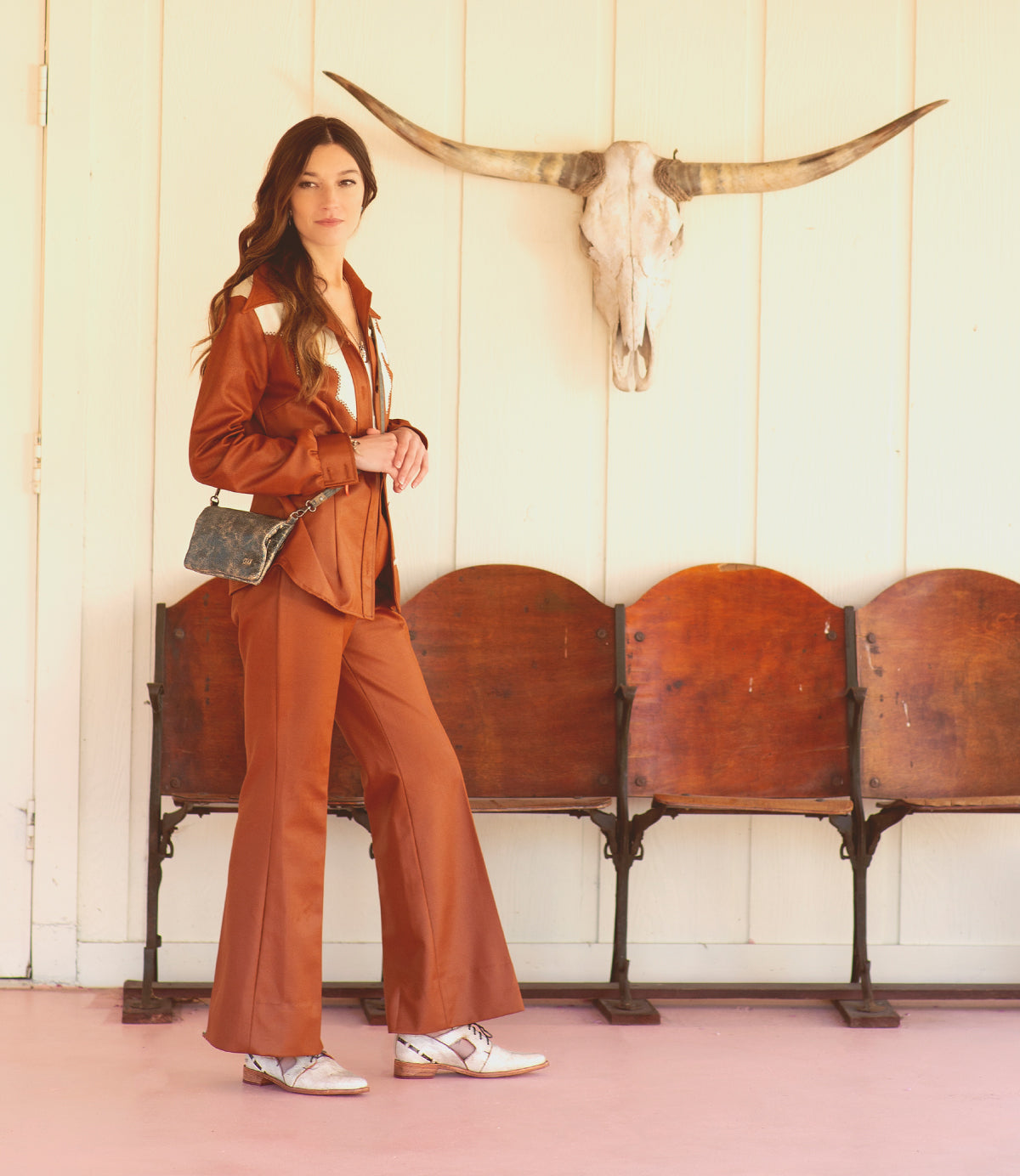 A woman wearing a Bed Stu Cadence brown pure leather clutch.