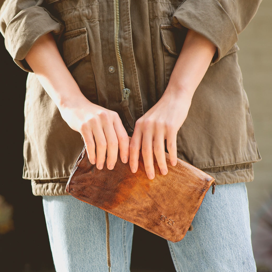 A woman holding a Cadence clutch by Bed Stu.