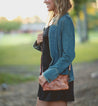 A woman wearing a denim jacket and a Bed Stu Cadence purse.