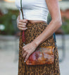 A woman in a leopard skirt holding a Bed Stu Cadence purse.