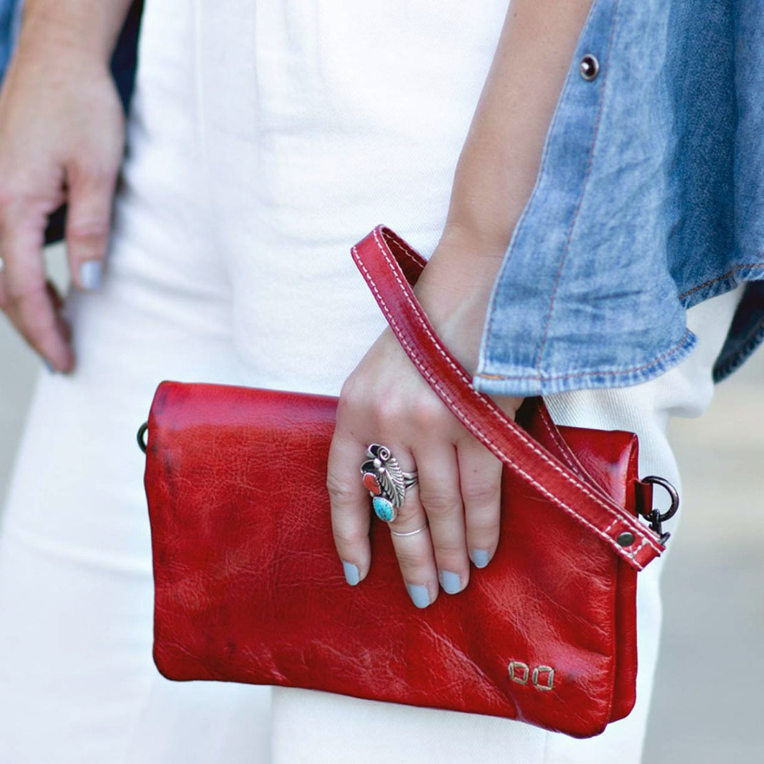 A woman holding a red leather Cadence clutch by Bed Stu.