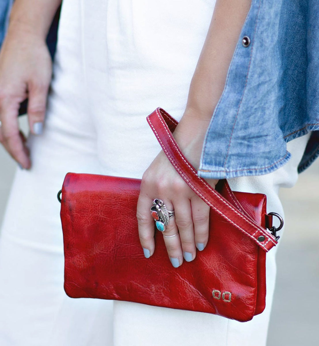 A woman holding a red leather Cadence clutch by Bed Stu.