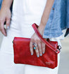 A woman holding a red leather Cadence clutch by Bed Stu.