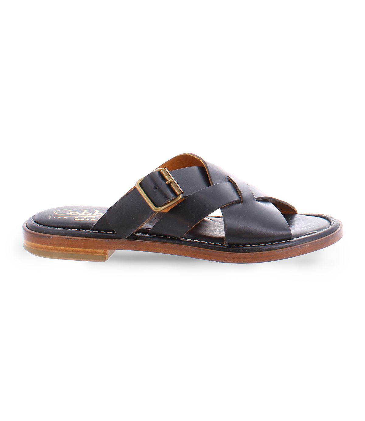 A black slip on Italian leather sandal with a gold buckle product shot.