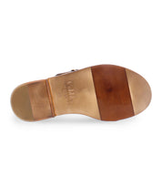 A black slip on Italian leather sandal with a gold buckle sole product shot.
