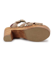 The Bed Stu Caitlin II features a wooden heel, a textured sole for grip, and metal rivets securing the leather straps, with visible stud accents viewed from the bottom.