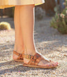 A woman wearing Bed Stu tan Callista sandals.