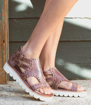 A woman's feet in a pair of Bed Stu Camden sandals.