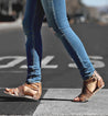 A woman wearing Capriana jeans and Bed Stu sandals crossing the street.