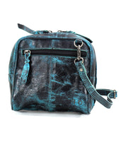 The Capture by Bed Stu is a small, textured black leather crossbody bag with blue accents. It features a front zipper pocket and an adjustable strap, showcasing artisan-made finishes for a touch of unique craftsmanship.