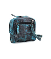 Introducing the Capture by Bed Stu: a compact, square-shaped leather handbag in a stunning teal and black marbled pattern. It features a front zipper pocket and a detachable shoulder strap. Made from eco-friendly leather, this bag also boasts exquisite artisan-made finishes.