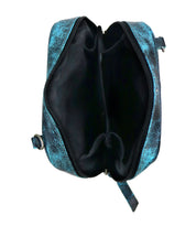 A top view of the Capture bag by Bed Stu, showcasing its compact blue textured design with a zippered main compartment that reveals two inner pockets and artisan-made finishes.