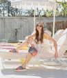 A woman sitting on a white lounge chair wearing Cadence by Bed Stu.