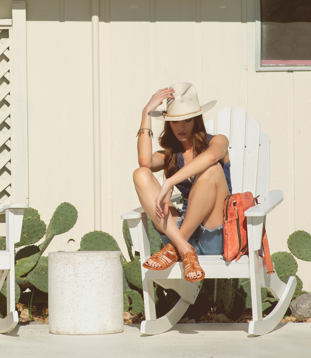 A woman sitting on a Bed Stu Cara rocking chair.