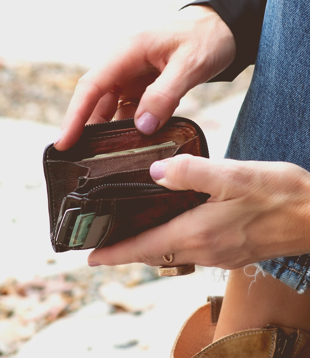 A woman holding a Bed Stu Carrie wallet in her hands.