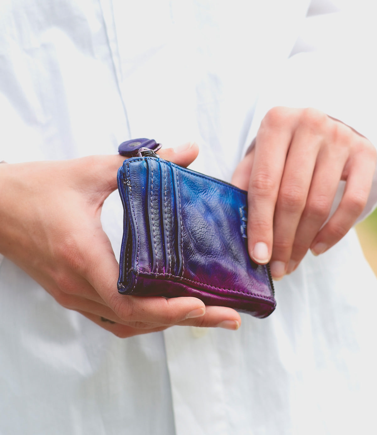 A person holding a purple and blue Bed Stu Carrie wallet.
