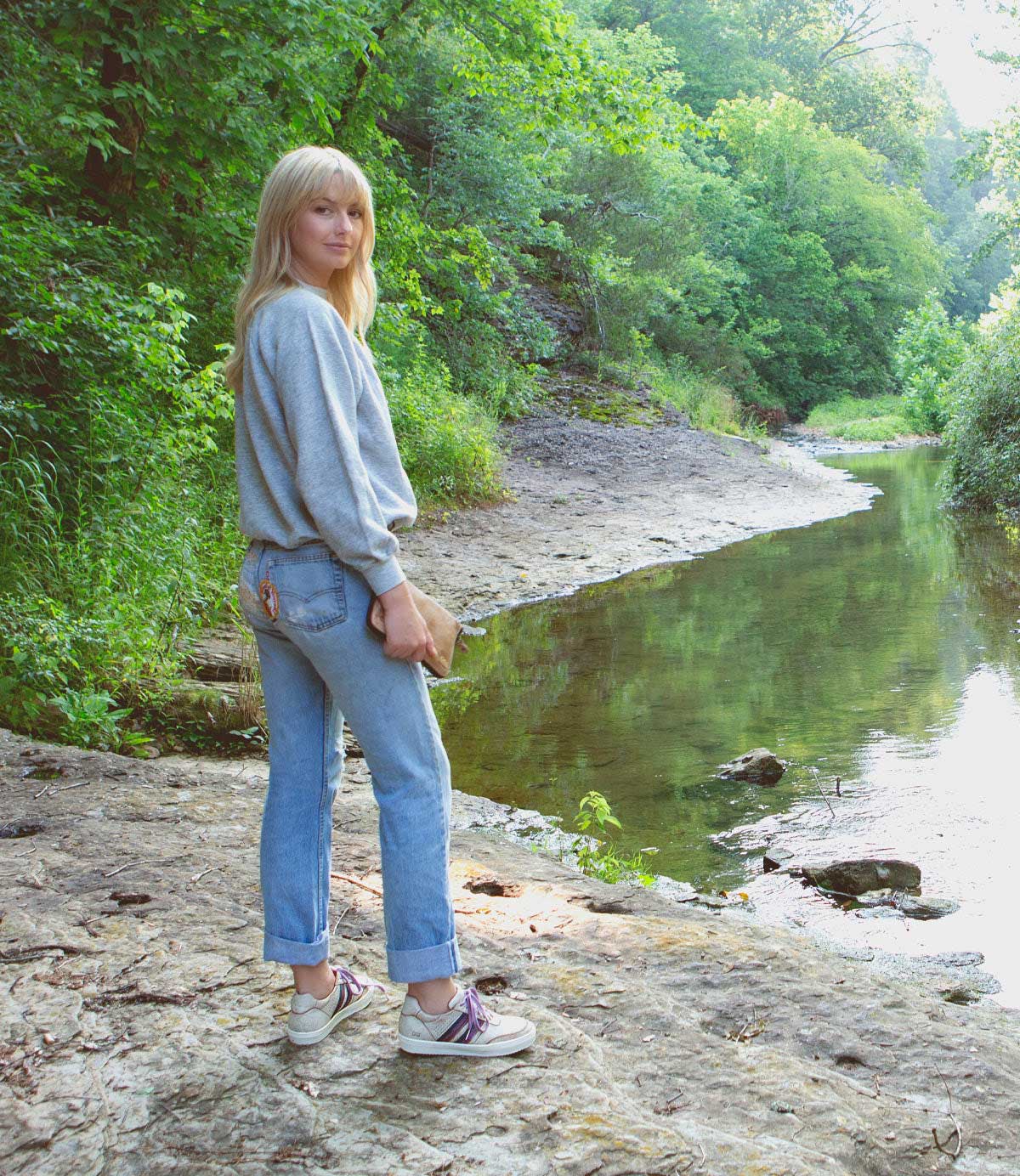 A woman standing next to a Carrington river by Bed Stu.