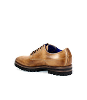 The "Carter" by Bed Stu is a men's brown leather oxford shoe featuring black laces and a rugged sole, expertly crafted with Goodyear welt construction, shown in side and back views.
