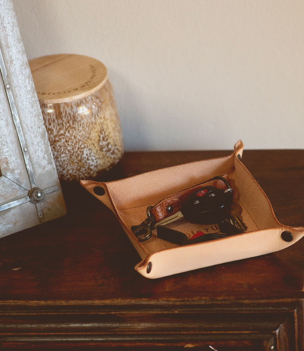 A Bed Stu Expanse leather tray with a pair of scissors on it.