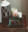 A small tray with an Expanse candle and a Bed Stu candle holder.