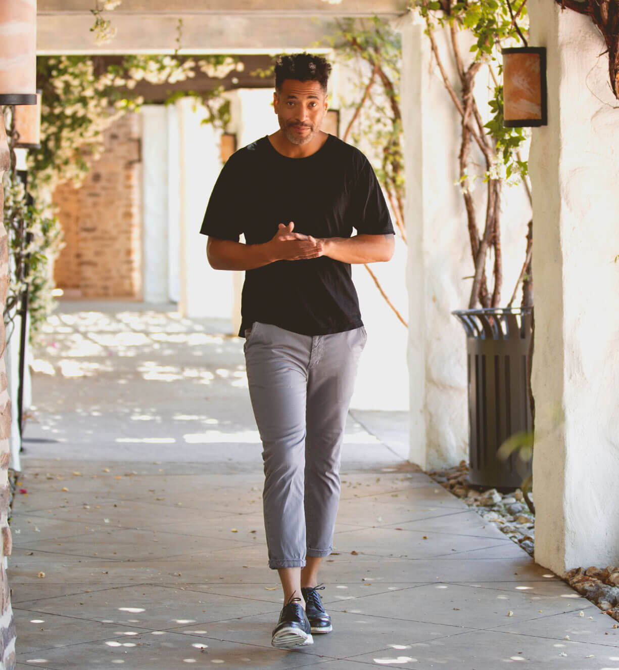 A man walking down a pathway with a Bed Stu Cayuga II in his hand.