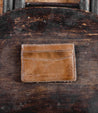 A brown leather Chuck card holder sitting on top of a wooden chair, made by Bed Stu.