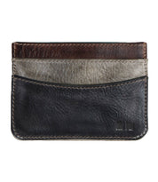 The Chuck by Bed Stu is a compact leather card wallet with three pockets in black, gray, and brown. It features visible stitching and a small logo in the bottom right corner, designed for everyday use.