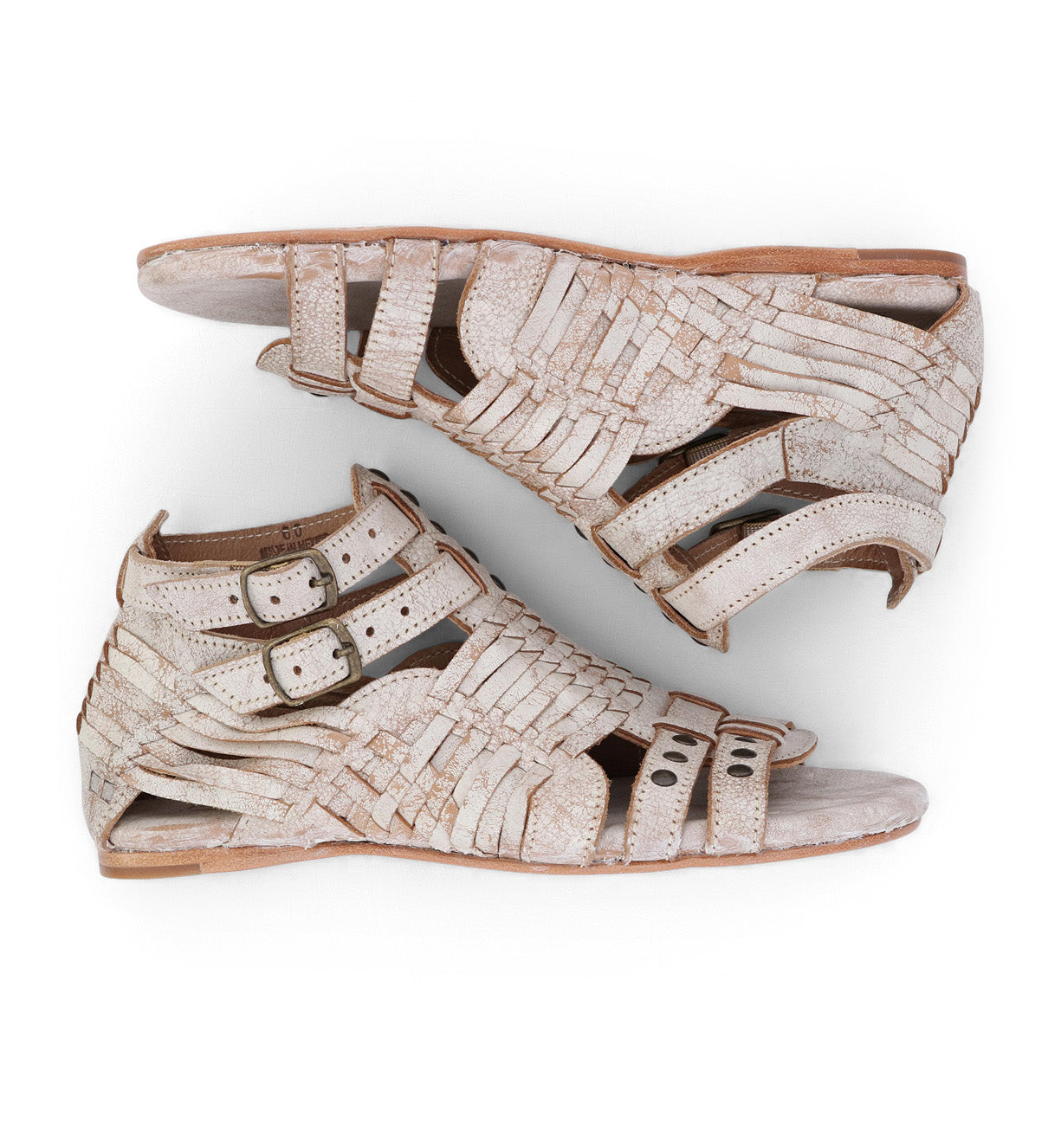 A pair of Claire white sandals with straps and buckles from Bed Stu.