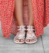 A woman wearing Claire sandals and a red skirt by Bed Stu.