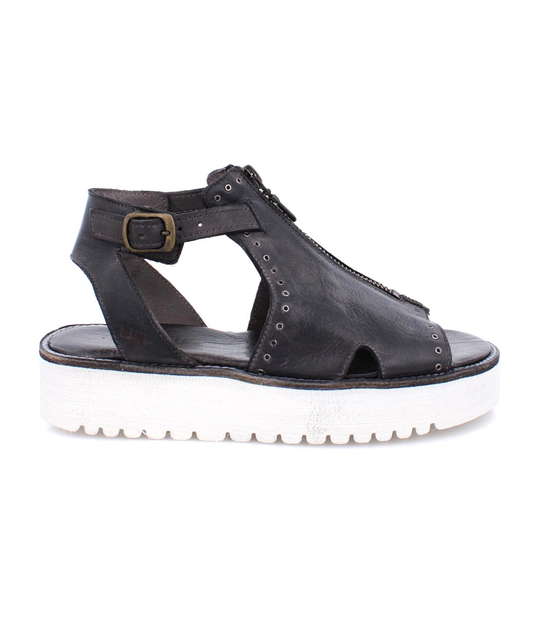 A Clancy sandal by Bed Stu, made of black leather with a white sole.