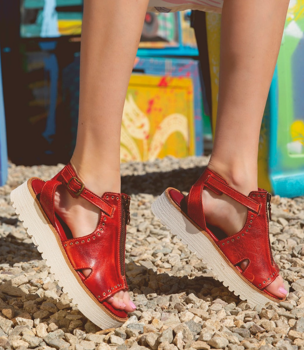 Woman wearing Clancy sandals by Bed Stu, made of red leather with a white sole.