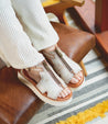 Woman wearing Clancy white leather sandal with white sole by Bed Stu.