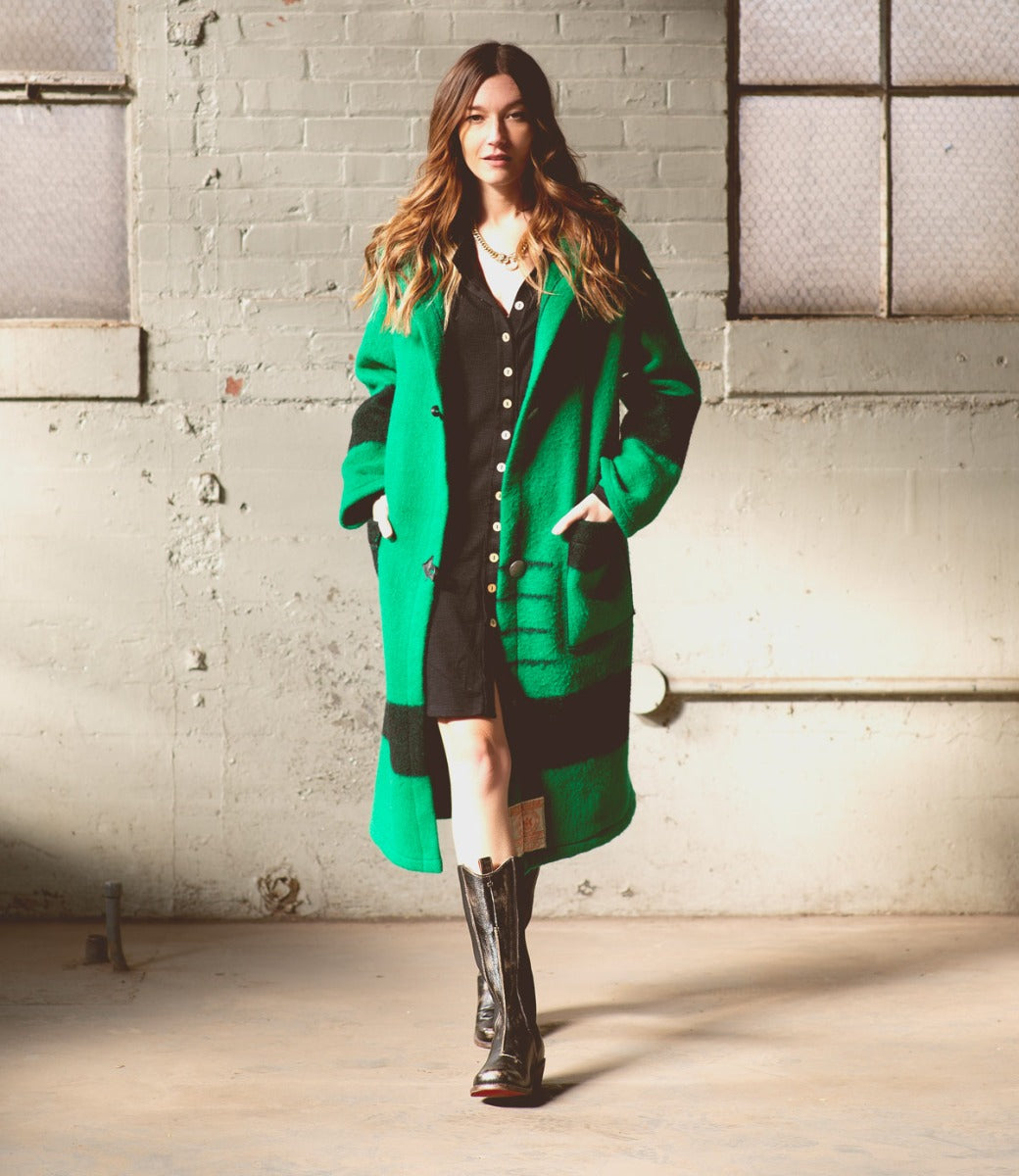 A woman wearing a coat and Clarisse boots by Bed Stu.