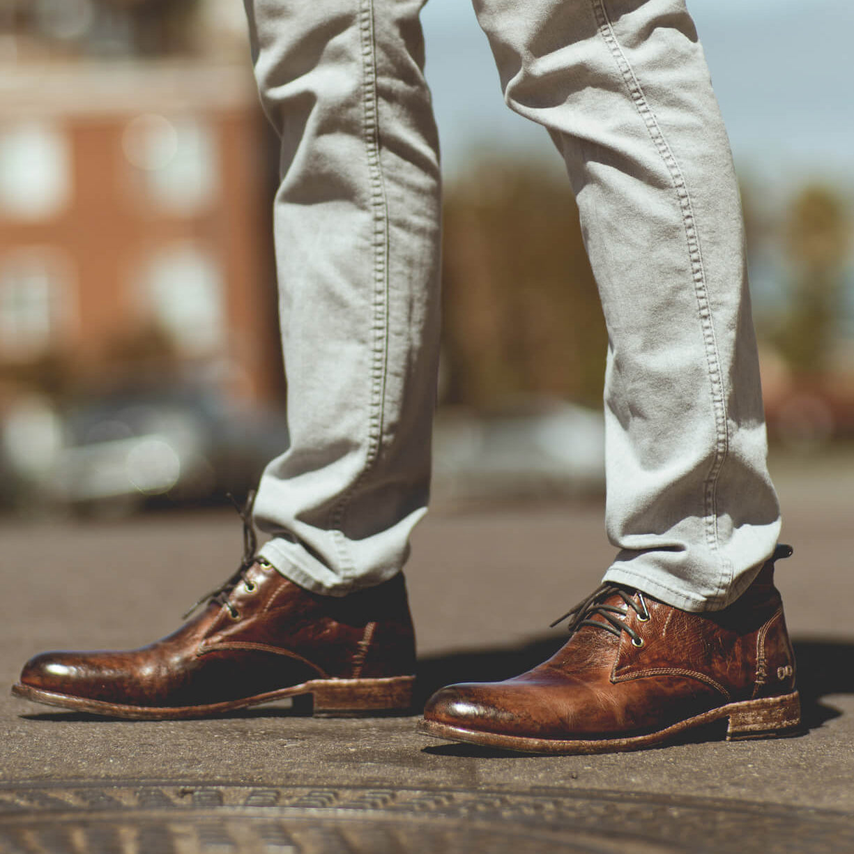 A man's feet standing on a Clyde manhole from the brand Bed Stu.