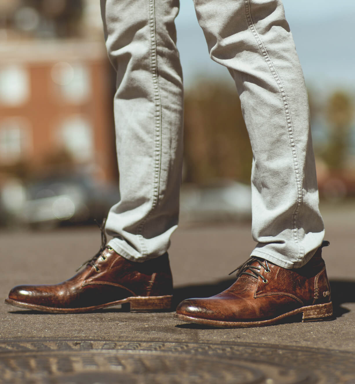 A man's feet standing on a Clyde manhole from the brand Bed Stu.