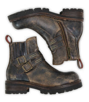 The Bed Stu Daring boots are distressed brown leather ankle boots featuring side zippers, adjustable buckle straps, red heel loops, and chunky rubber soles.