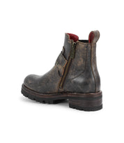 The Bed Stu Daring is a distressed brown leather ankle boot featuring adjustable buckle straps, side zipper, chunky heel, treaded sole, and red interior lining, shown from the back and side.