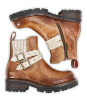 The Bed Stu Daring boots are brown leather ankle boots with beige adjustable buckle straps and zippers, shown side by side on a white background for a rugged style look.