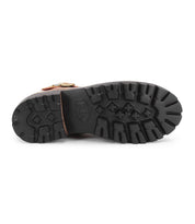 Close-up of the Bed Stu Daring boot's black rubber sole with deep lugs and cross-shaped treads, plus a glimpse of the brown upper, highlighting its rugged style.