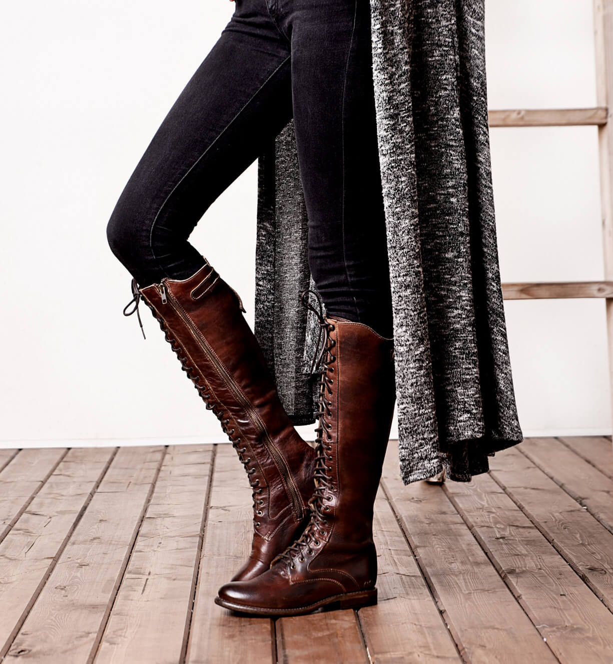 A woman is standing on a ladder in a pair of Bed Stu Della boots.