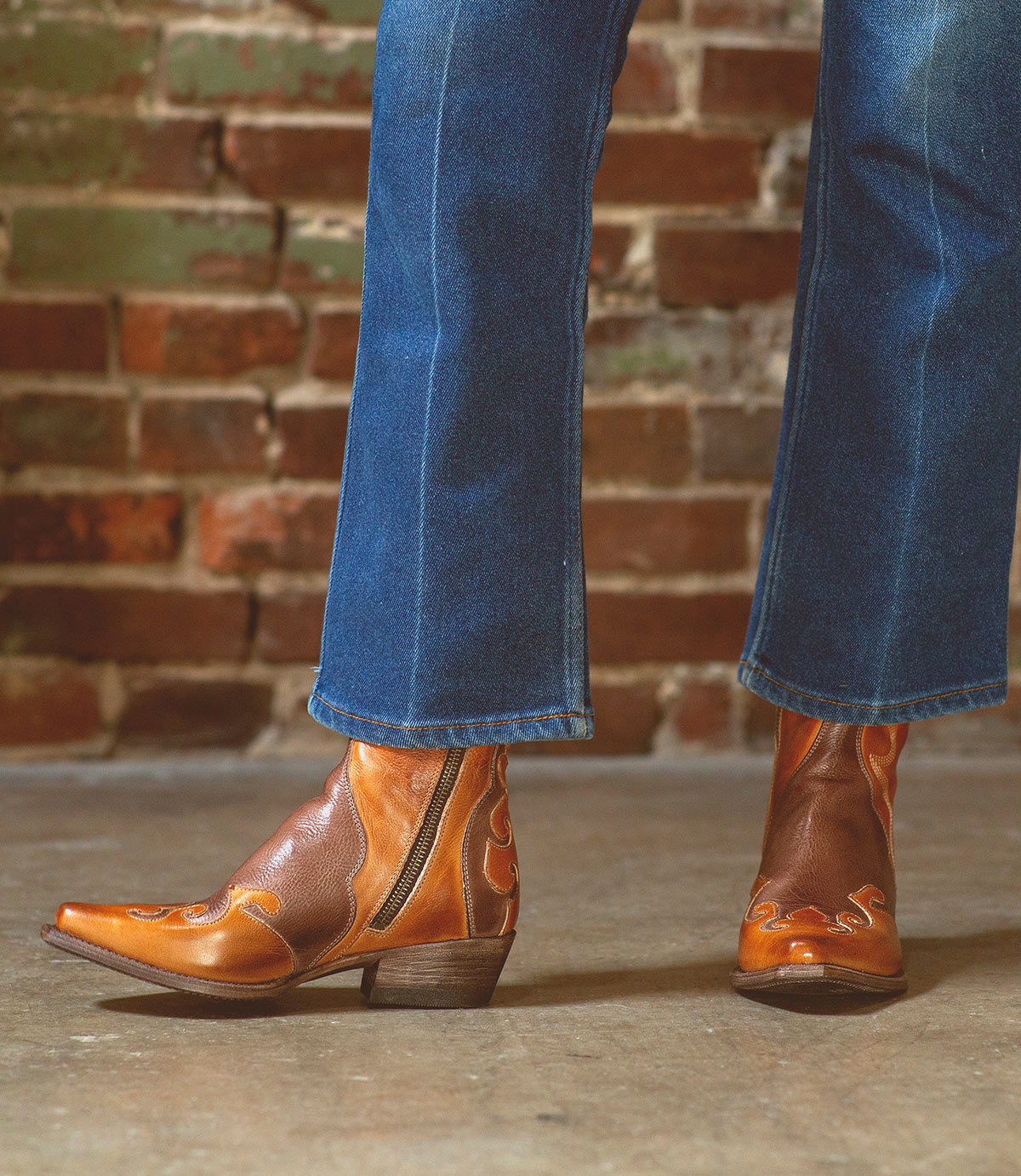 A woman exuding rustic charm in her Bed Stu Deuce jeans and leather cowboy boots.