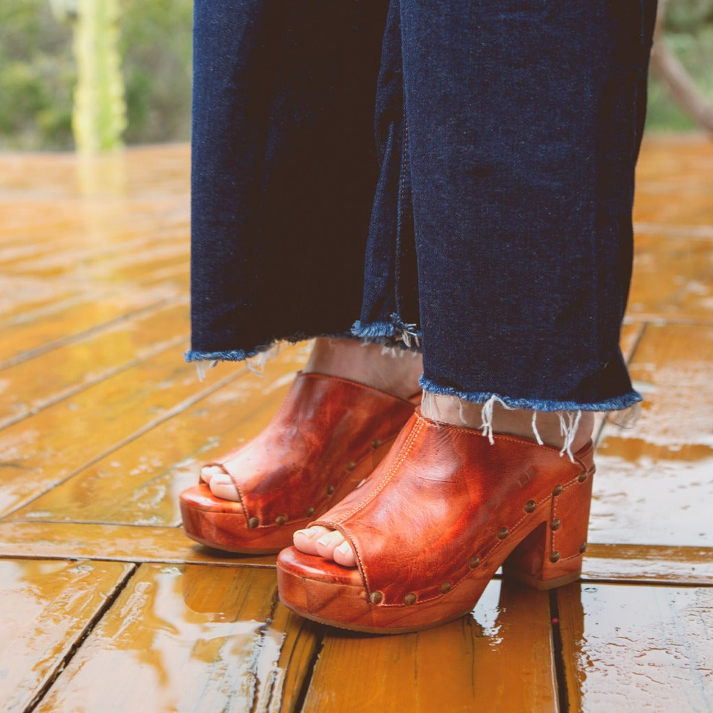 A woman wearing leather Deva clog with wooden heels by Bed Stu.