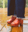 A woman wearing leather Deva clog with wooden heels by Bed Stu.