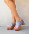 A woman wearing a pair of Bed Stu tie dyed Deva clogs.