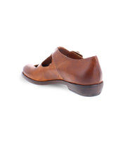 A product shot of a  brown leather shoe for women made with Italian leather and has cutouts in a t-strap  type of shoe. 
