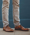 A man wearing a pair of brown Bed Stu Donatello shoes.