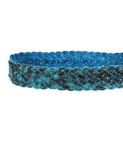 The Dreamweaver belt by Bed Stu, featuring an intricate braided pattern in wide blue and black woven material and a round brass-tone buckle, displayed against a white background.