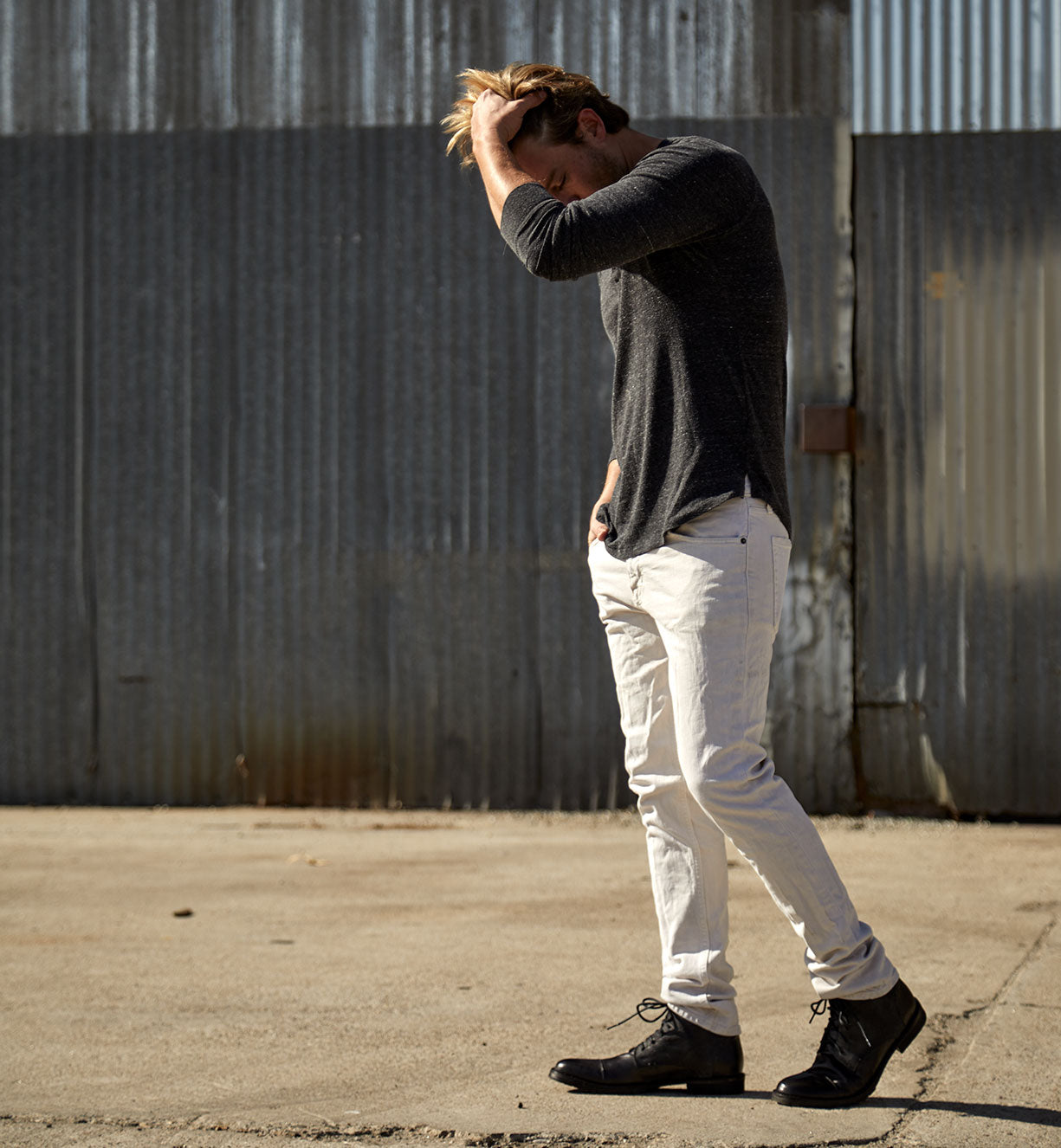 A man wearing a Bed Stu Dreck shirt and white pants.