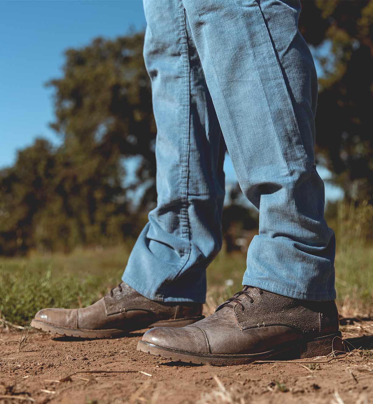 A man's feet standing on a Bed Stu Dreck field.