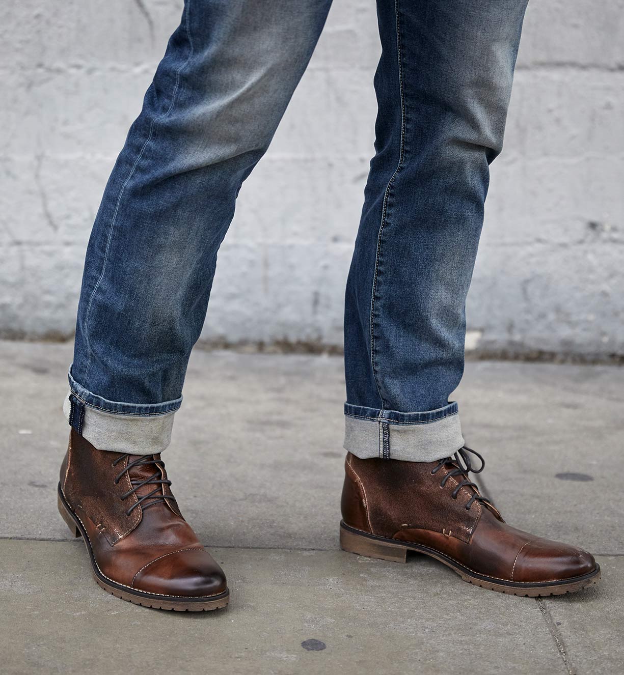 A man wearing jeans and a pair of Bed Stu Dreck boots.